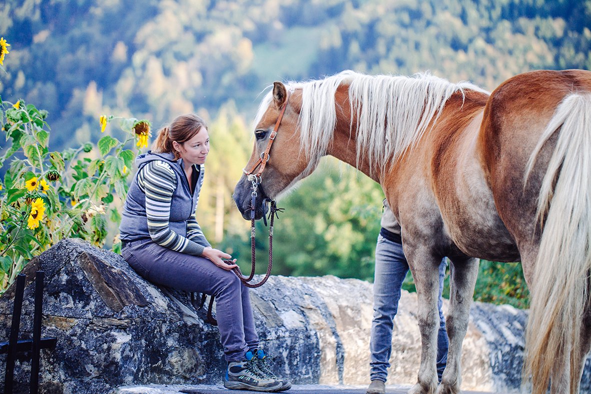 Pferd bei der Propstei St. Gerold Foto einer Frau und eines Pferds in der Propstei St. Gerold