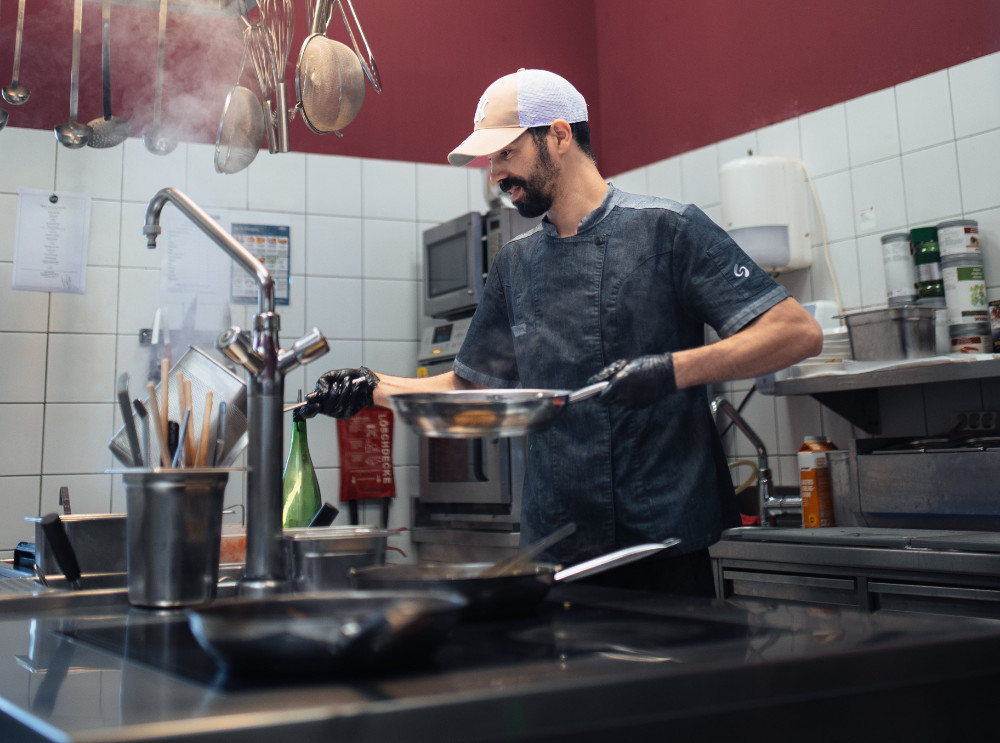 A chef prepares a dish in the kitchen.