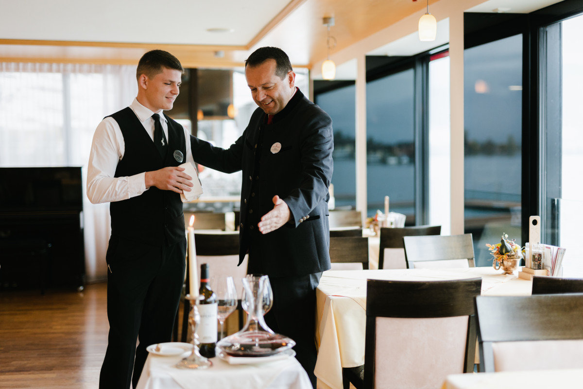Lehre als Restaurantfachmann Foto von Lehrling im Service mit Kollegen