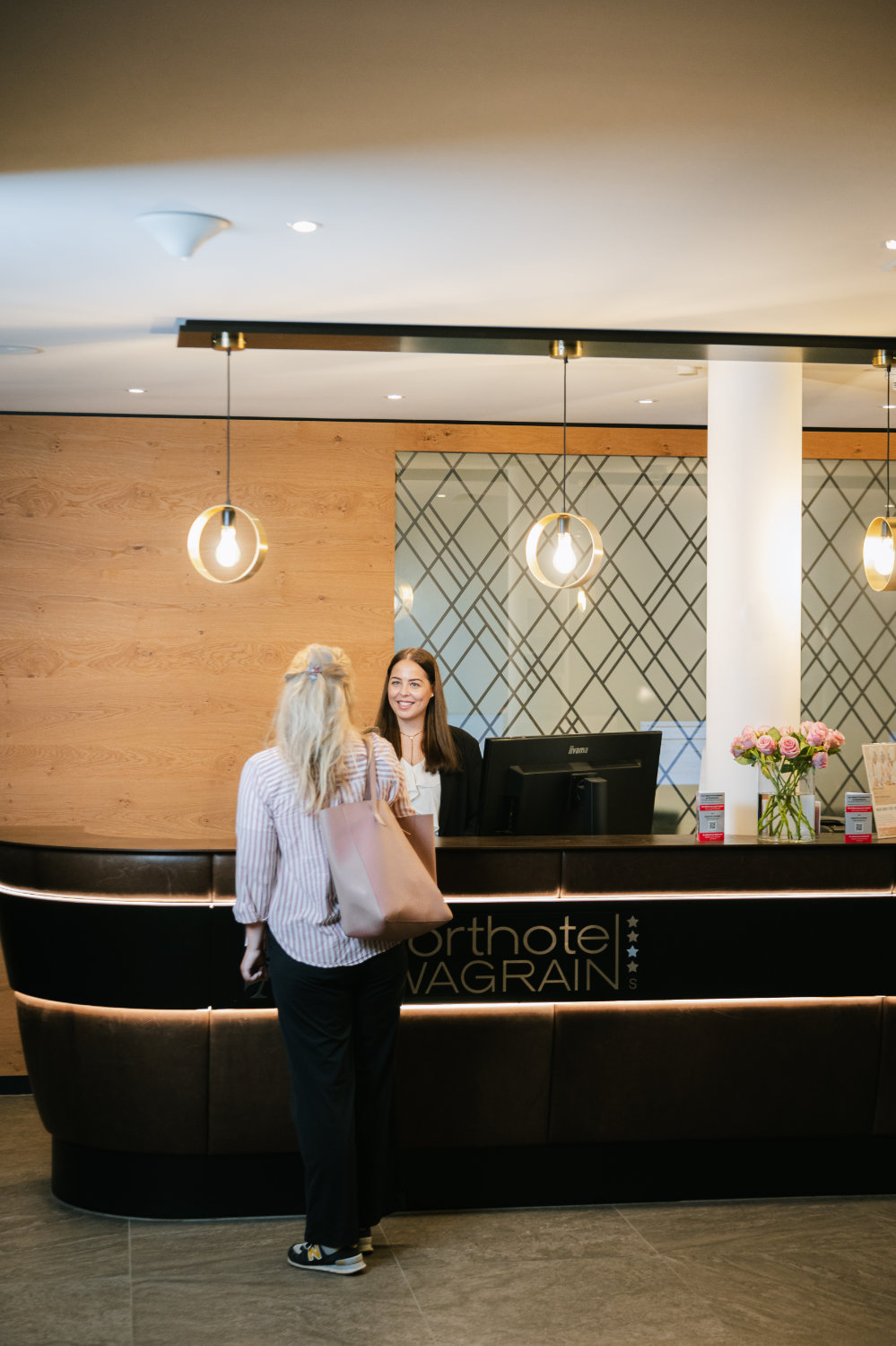 Ein Gast steht an der Rezeption in einer Hotellobby.