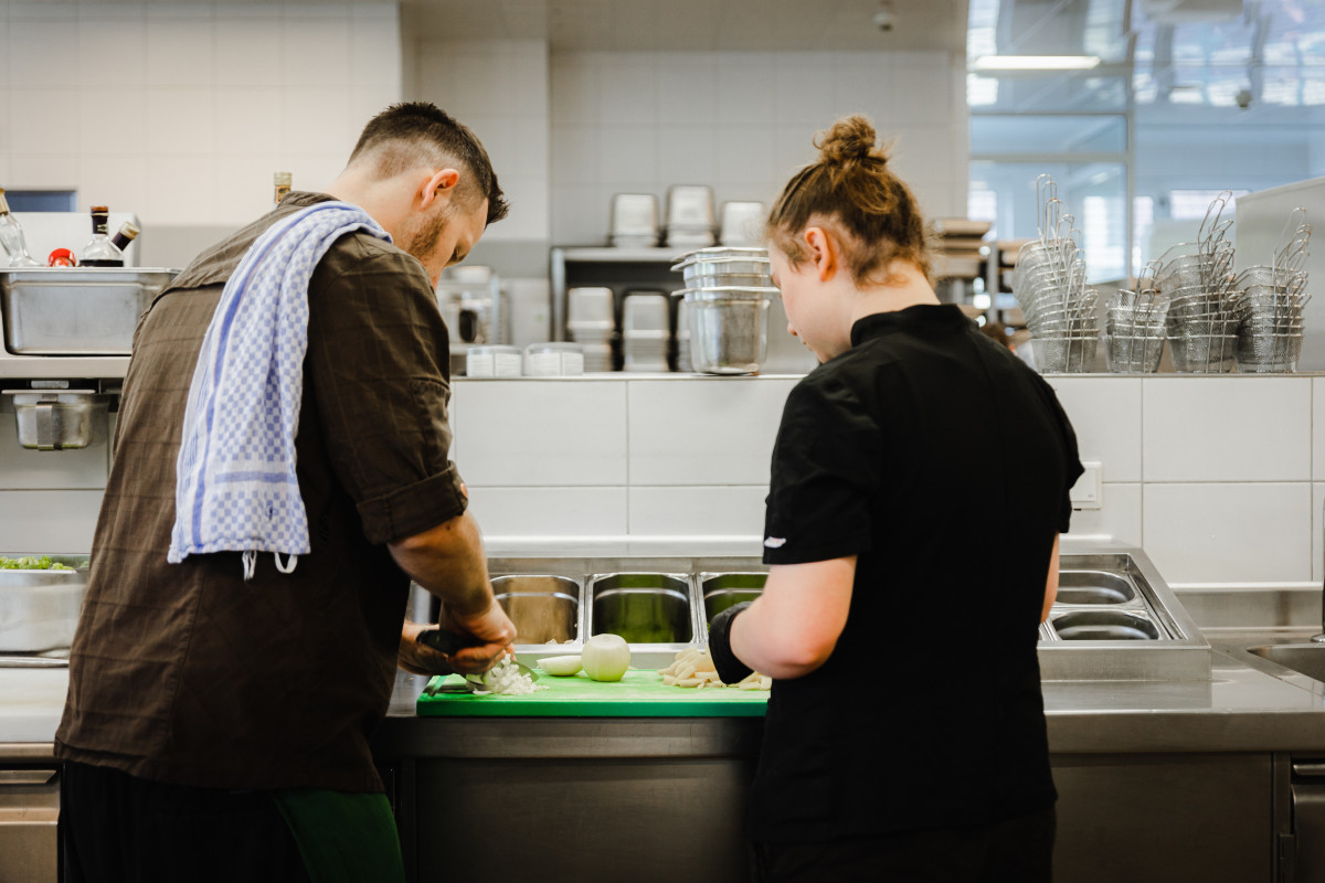 Lehrling im Laschenskyhof am Kochen Foto von Lehrling mit Betreuer am Zubereiten