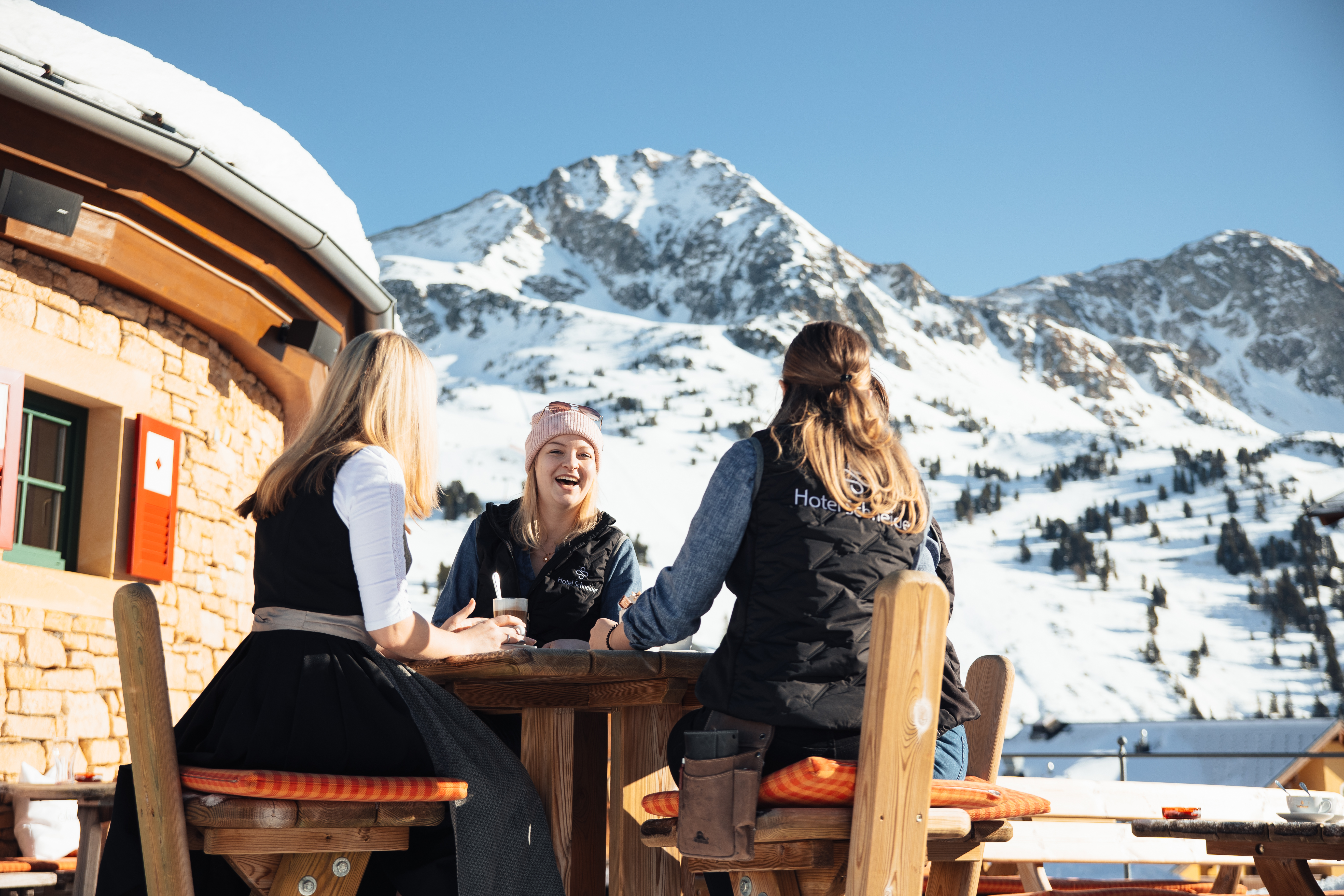 Foto von Gästen die in der Sonne einen Kaffee trinken