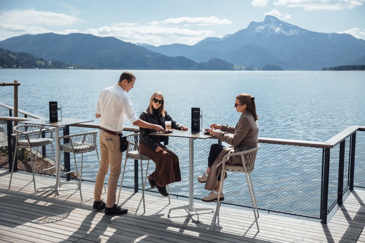 Two guests and a service employee at the lake