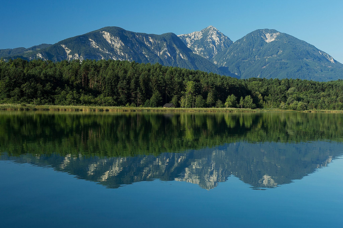Eine Bergkulisse spiegelt sich im davorliegenden See.