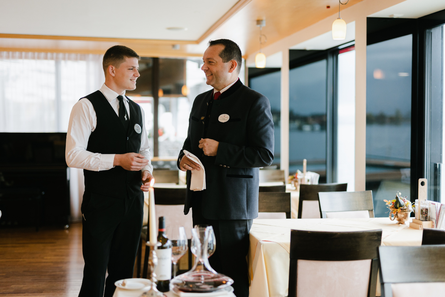 Zwei Servicekräfte stehen in einem Restaurant und unterhalten sich.