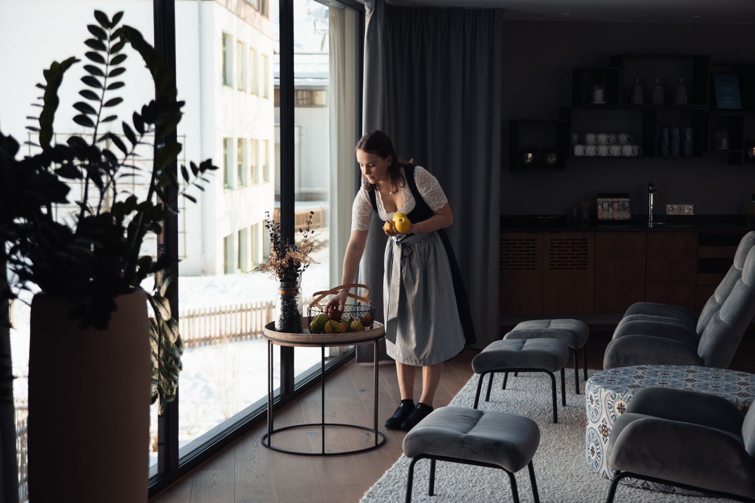 A young woman fills the fruit basket in a hotel room.
