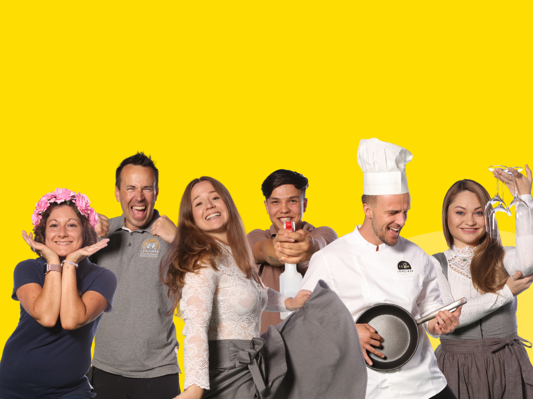 Team der Löwe & Bär Hotels Teamfoto vor gelben Hintergrund