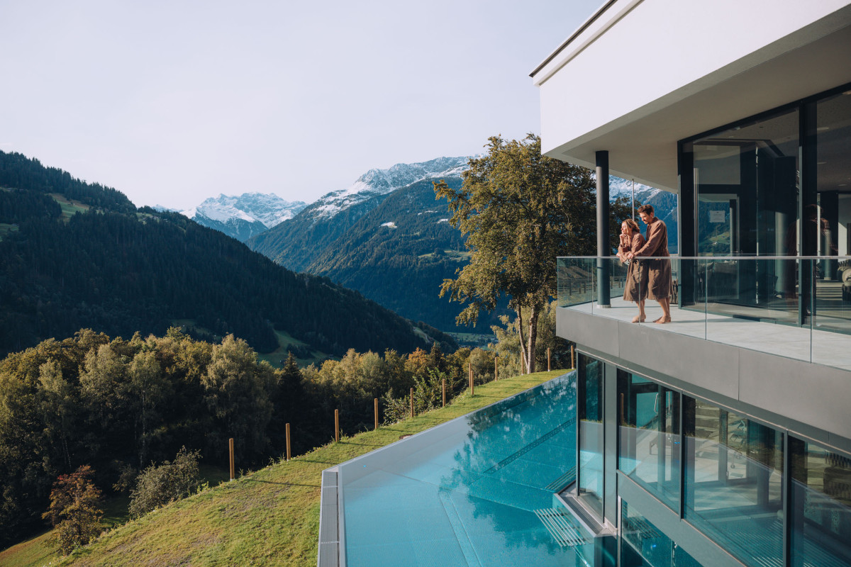 Auf dem Balkon des Hotels "Fernblick Montafon" steht ein Pärchen in Bademantel und genießt die Aussicht.