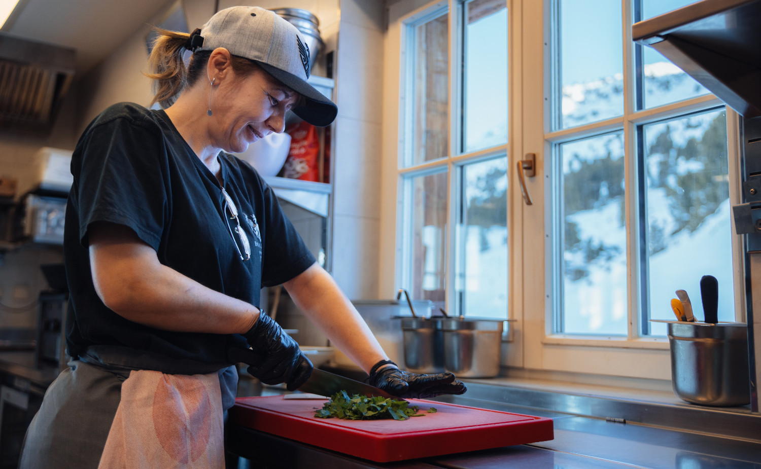 A female chef cuts vegetables in the kitchen.