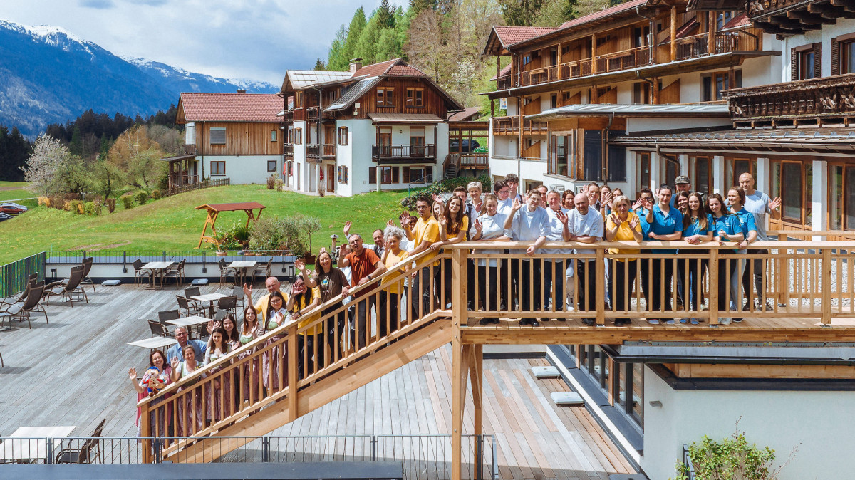 Das ganze Team des Familienhotels RAMSI steht auf einer Treppe vor dem Hotel.