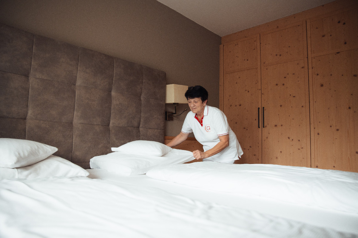 Hotelmitarbeiterin macht ein Bett.