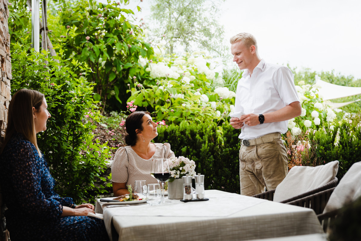 Von Service bis Küche ist bei der Gastronomiefach-Lehre alles dabei! Foto von Kellner bei Gästeberatung