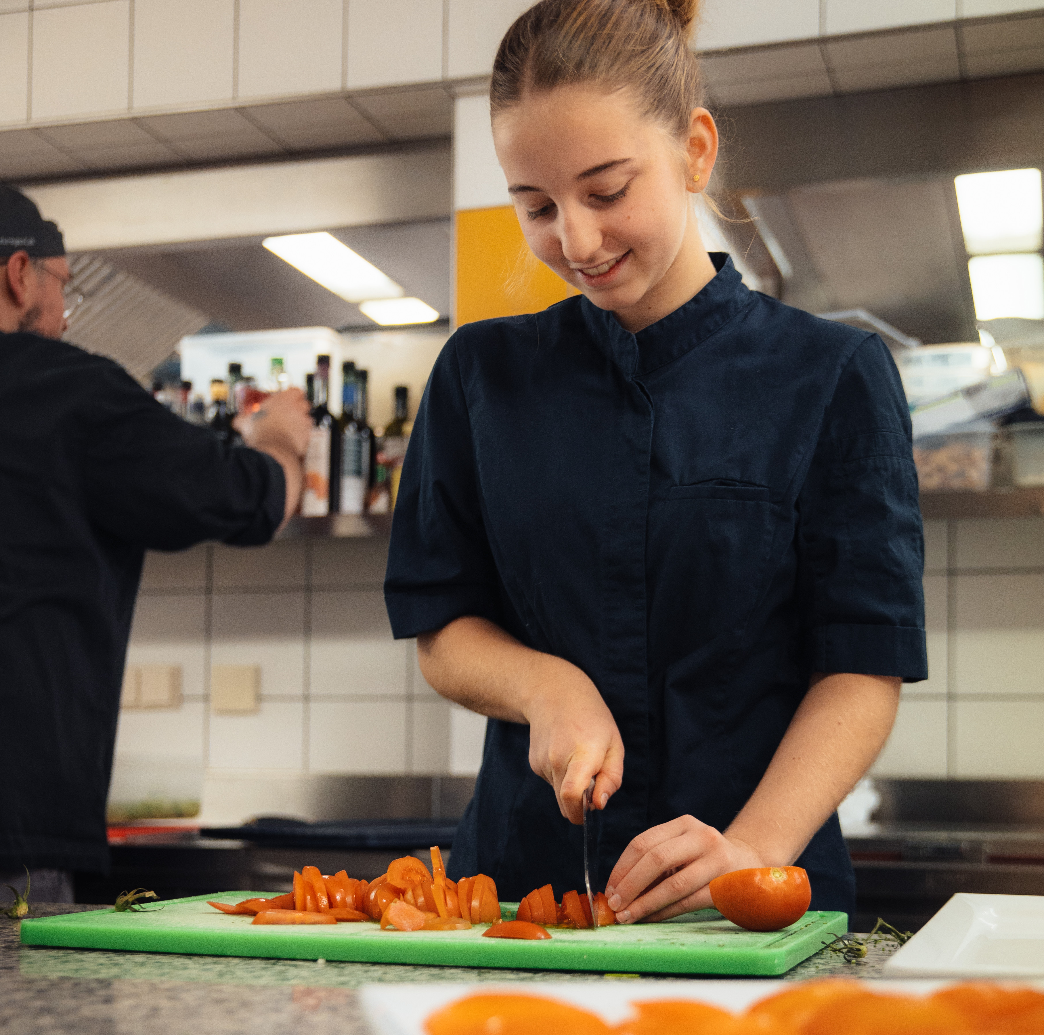 Foto einer Köchin beim Schneiden von Tomaten